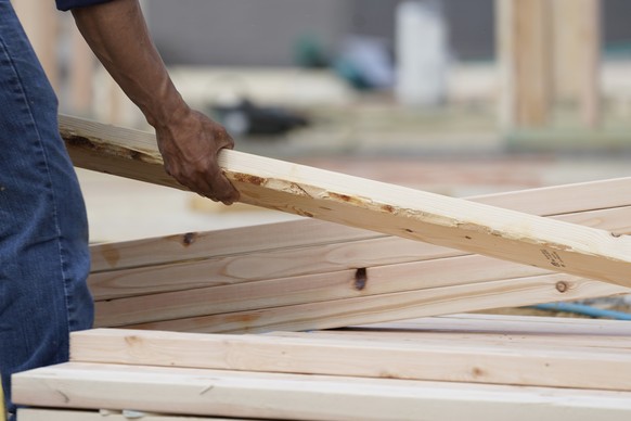 A workman arranges a beam on a frame at a new housing site in Madison County, Miss., Tuesday, March 16, 2021. Rising prices for a variety of commodities are contributing to a jump in prices at the con ...