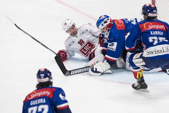 Der Zuercher Lukas Flueeler, Mitte rechts, spielt um den Puck Gaetan Augsburger, Mitte links, von Lausanne beim Eishockeyspiel der National League ZSC Lions gegen dem Lausanne HC im Hallenstadion in Z ...