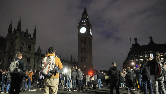 People hold a minute of silence for the late Queen Elisabeth II at Westminster Bridge in front of Big Ben in London, England, Sunday, Sept. 18, 2022. The funeral of Queen Elizabeth II, Britain&#039;s  ...