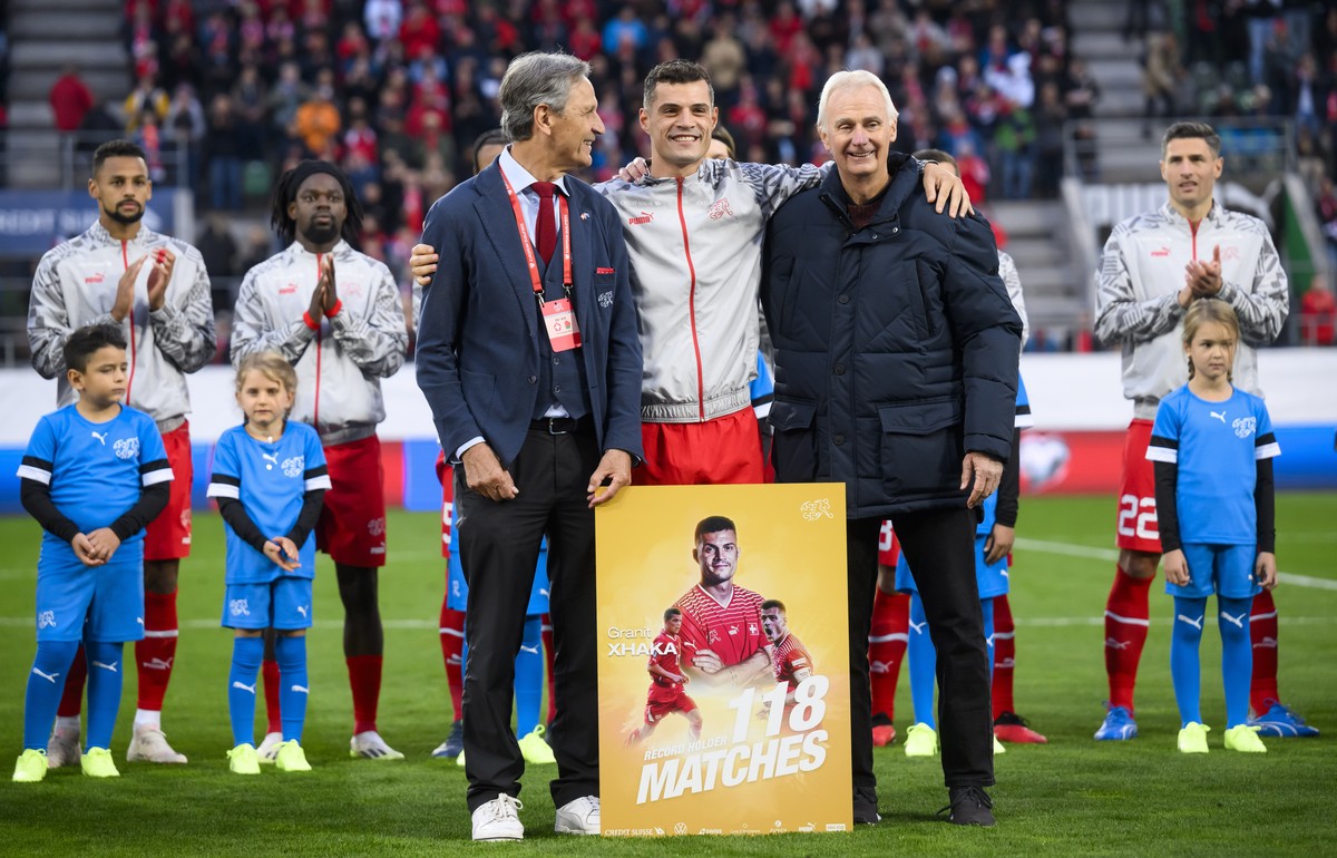 Switzerland's midfielder Granit Xhaka, center, is honored for his 118th selection for the Swiss national team with Switzerland's soccer federation president Dominique Blanc, left, and Werner ...