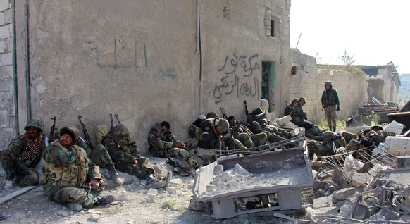 epa05673149 Syrian soldiers resting following the battle at al-Sheik Saeed neighborhood in Aleppo, Syria, 12 December 2016. The army recaptured the neighborhood on 12 December 2016 following clashes w ...