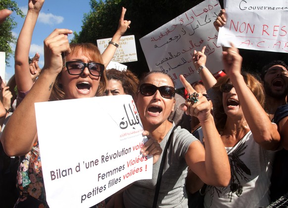 FILE - In this Oct.2, 2012 file photo, hundreds of Tunisian women protest in support of a woman who says she was raped by police and is facing accusations of violating modesty laws in Tunis. A new pol ...