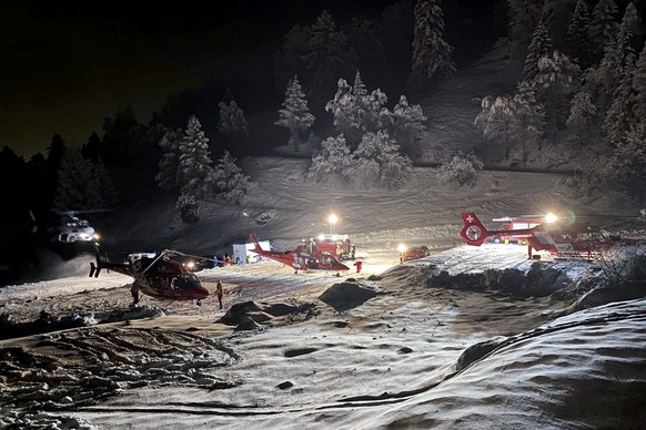 HANDOUT - Mountain rescuers and helicopters prepare to fly to the Tete Blanche mountain in the Swiss alps mountains, near Sion, Switzerland, Sunday, March 10, 2024. Five cross-country skiers who went  ...