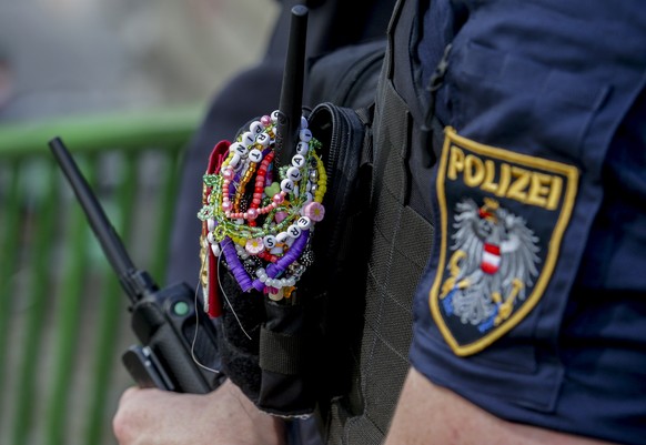 An Austrian police officer is decorated with bracelets in the city centre in Vienna on Thursday, Aug.8, 2024. Organizers of three Taylor Swift concerts in the stadium in Vienna this week called them o ...
