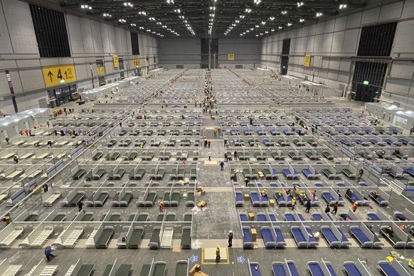 In this photo released by Xinhua News Agency, workers labor at the site of a temporary hospital being constructed at the National Exhibition and Convention Center (Shanghai) in east China&#039;s Shang ...