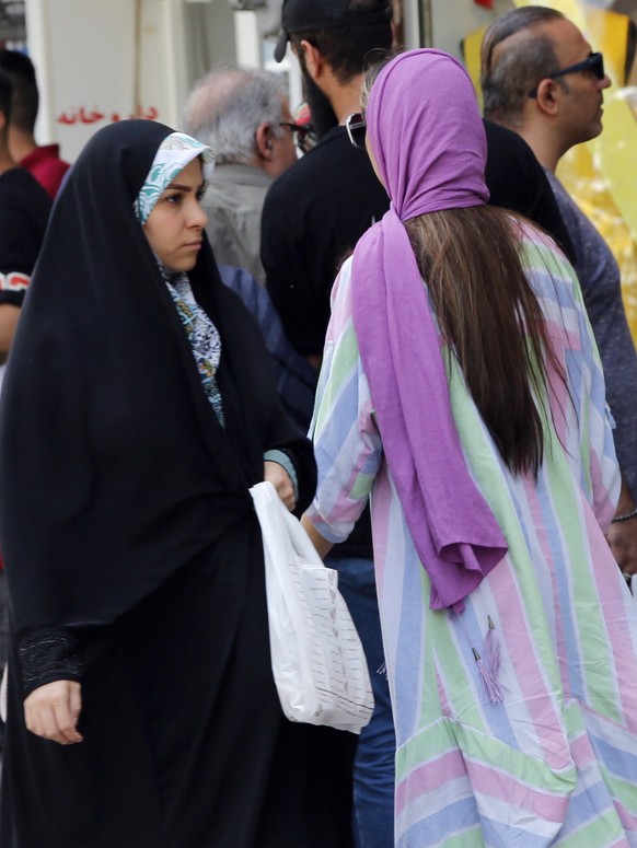 epa10066449 Iranian women walk in a street of Tehran, Iran, 12 July 2022. Iranian Police started to warn women about their dress code and hair style in the most cities especially in the capital city o ...