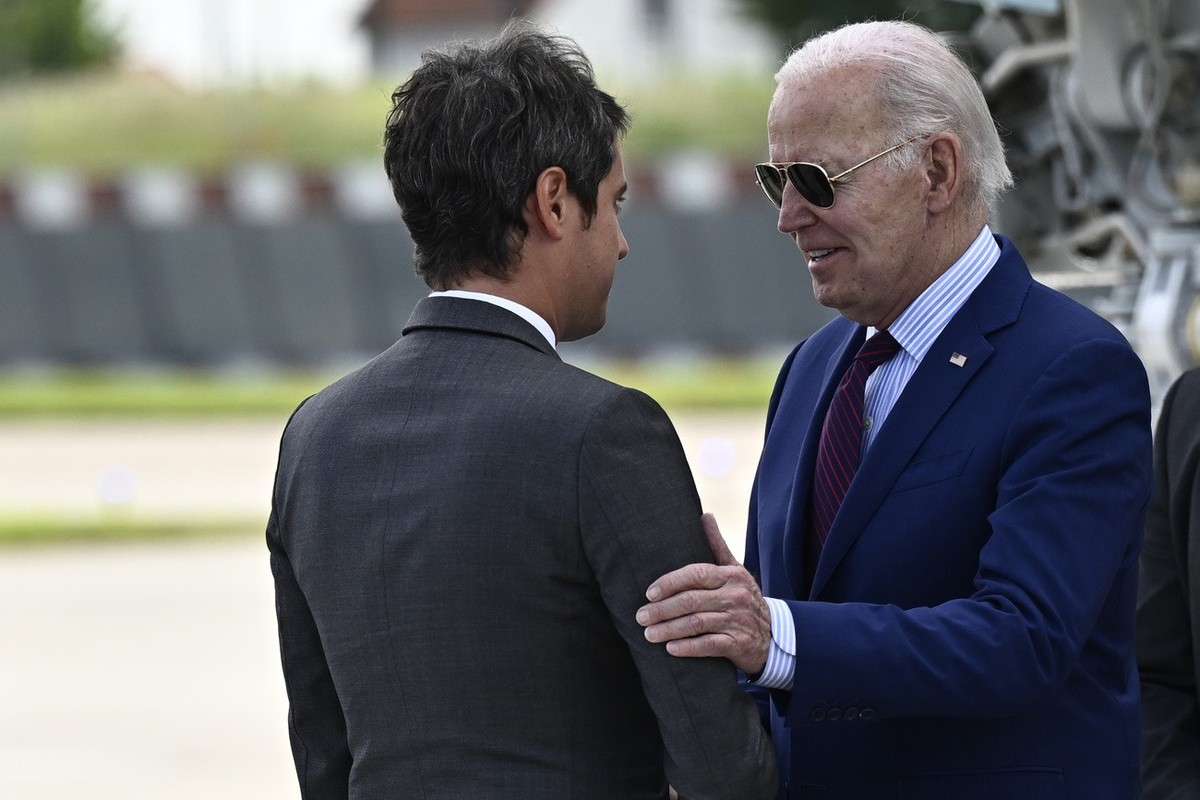 epa11390618 US President Joe Biden (R) is welcomed by France's Prime Minister Gabriel Attal (L) upon arrival at Paris Orly airport, near Paris, France, 05 June 2024. US President Biden arrived in ...
