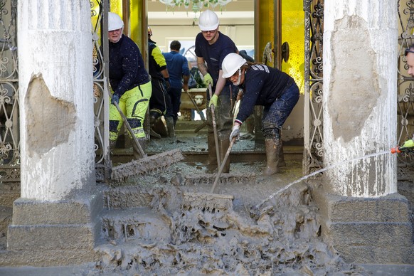 People remove mud and debris after heavy rainfall triggered landslides that collapsed buildings and left as many as 12 people missing, in Casamicciola, on the southern Italian island of Ischia, Sunday ...