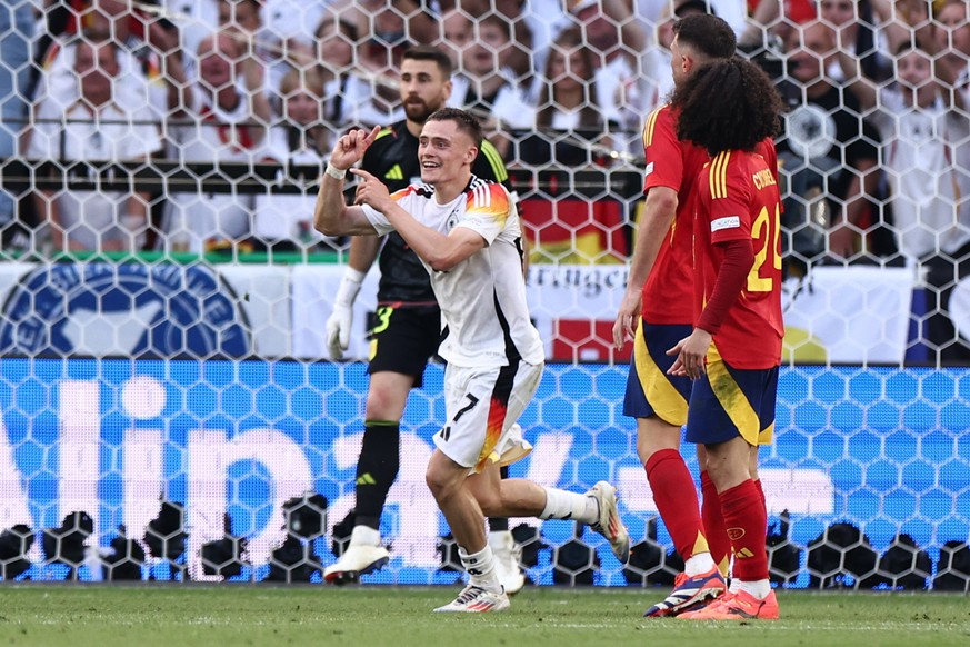 epa11460352 Florian Wirtz of Germany (C) gestures for a handball on Marc Cucurella of Spain (R) during the UEFA EURO 2024 quarter-finals soccer match between Spain and Germany, in Stuttgart, Germany,  ...