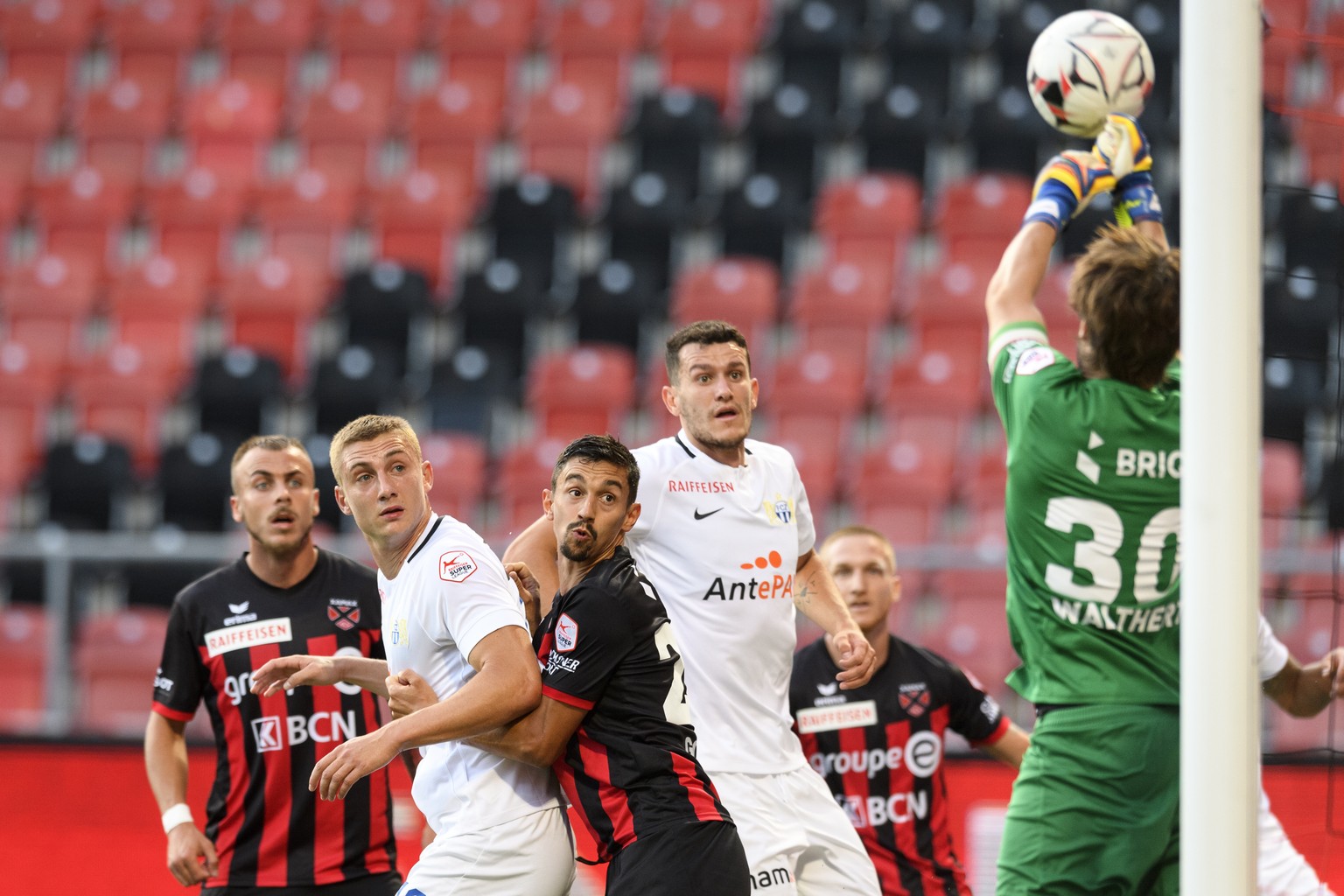 L&#039;attaquant zuerichois Blaz Kramer, gauche en blanc, et le defenseur zuerichois Nathan, droite en blanc, luttent pour le ballon avec le defenseur neuchatelois Mike Gomes, centre, et le gardien ne ...