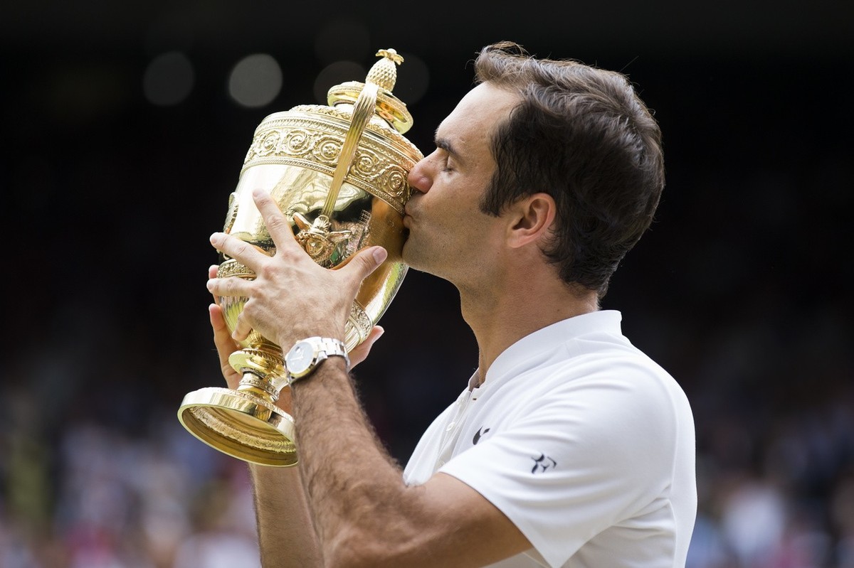Roger Federer of Switzerland kisses the trophy after winning the men's final match against Marin Cilic of Croatia during the Wimbledon Championships at the All England Lawn Tennis Club, in London ...