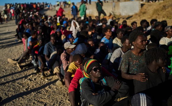 Migrants who crossed from Morocco into Spain line up for food distribution on a beach in the Spanish enclave of Ceuta, Monday, Aug. 3, 2026. (AP Photo/Bernat Armangue)
Migration Spain Ceuta