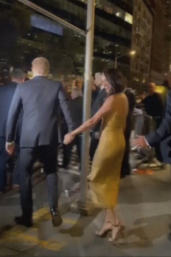 In this image from video, Prince Harry and his wife Meghan Markle exit Manhattan?s Ziegfeld Ballroom on Tuesday, May 16, 2023 in New York. The couple?s office says the pair and Meghan?s mother were fo ...