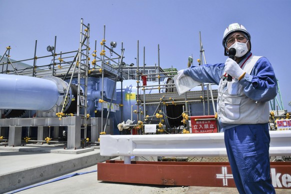 A Tokyo Electric Power Company employee explains about the facility that will be used to release treated radioactive water to media at the Fukushima Daiichi Nuclear Power Plant in Fukushima, northern Japan,…