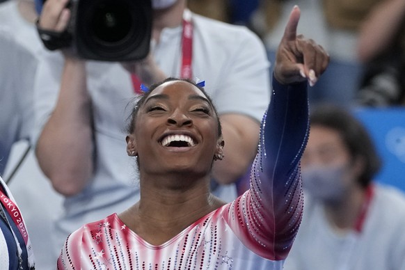 Simone Biles, of the United States, points at teammates on the stands after performing on the balance beam during the artistic gymnastics women&#039;s apparatus final at the 2020 Summer Olympics, Tues ...