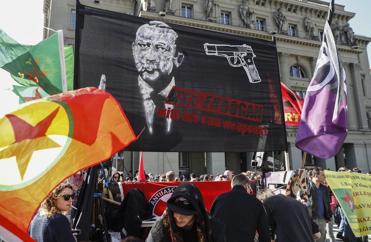 epa05870520 A banner reads; 'Kill Erdogan with his own weapons', as protesters march during a demonstration against the Turkish President Recep Tayyip Erdogan, in Bern, Switzerland, 25 March ...