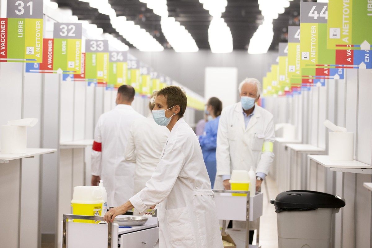 Les membres du staff medical changent de box pour vacciner contre le coronavirus COVID-19 les personnes a l'aide du vaccin Moderna, lors du premier jour d'ouverture du Centre de vaccination  ...