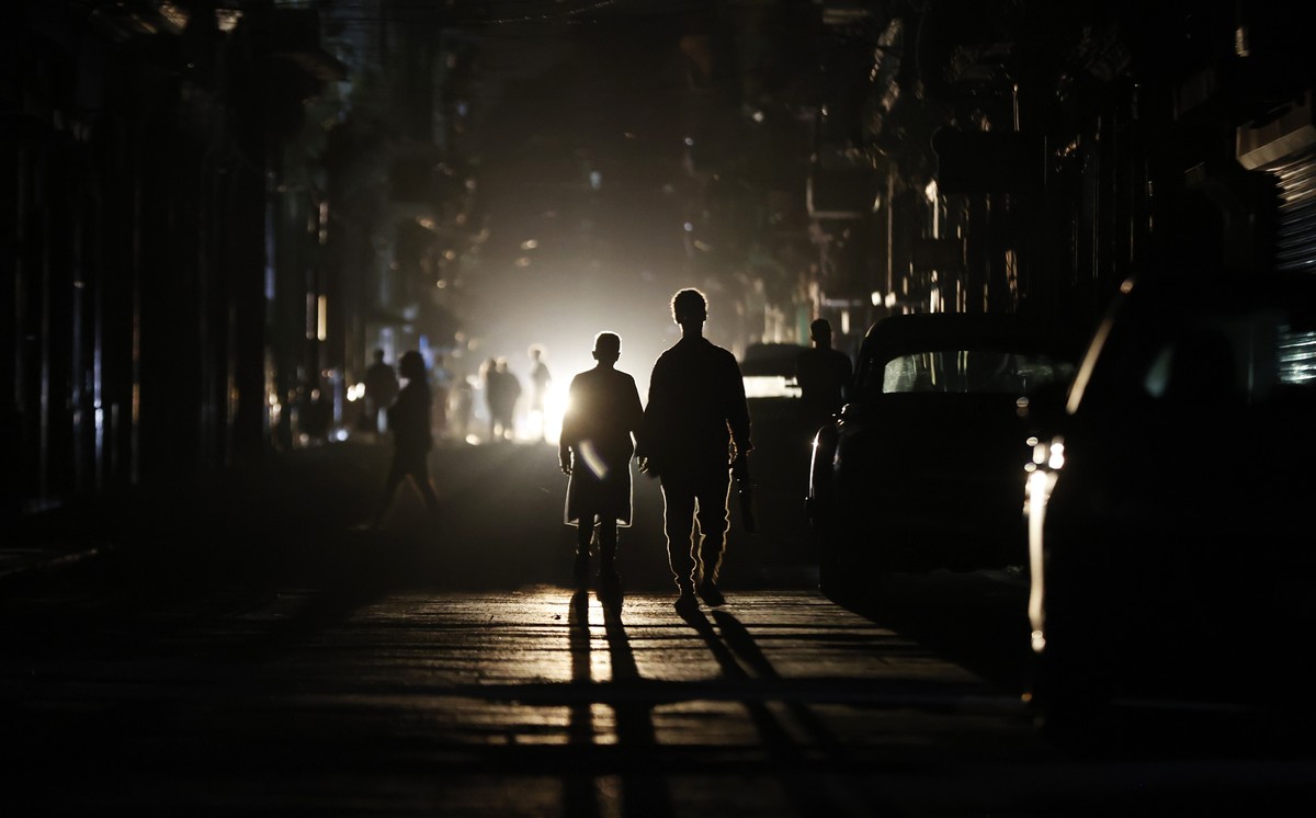 epaselect epa12840313 People walk down a street during a national power outage, in Havana, Cuba, 21 March 2026. Cuba experienced another nationwide blackout due to a total shutdown of the National Ele ...