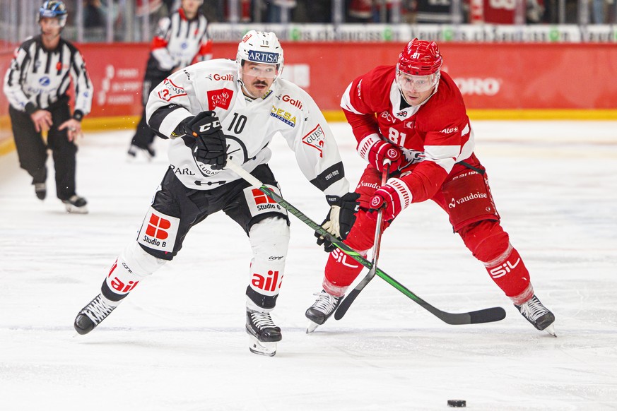 L&#039;attaquant luganais Alessio Bertaggia, gauche, lutte pour le puck avec l&#039;attaquant lausannois Ronalds Kenins, droite, lors de la rencontre du championnat suisse de hockey sur glace de Natio ...