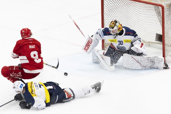 Ambri-Piotta&#039;s defender Isacco Dotti, left, vies for the puck with Lausanne&#039;s forward Damien Riat #9 past Ambri-Piotta&#039;s goaltender Janne Juvonen, right, during the third leg of the Nat ...