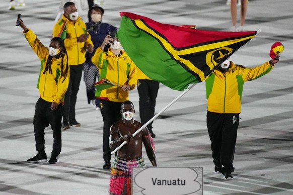 Riilio Rii, of Vanuatu, carries his country&#039;s flag during the opening ceremony in the Olympic Stadium at the 2020 Summer Olympics, Friday, July 23, 2021, in Tokyo, Japan. (AP Photo/David J. Phill ...