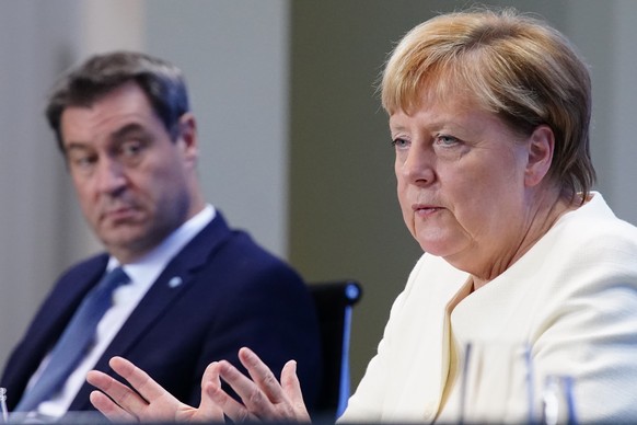 epa08706231 German Chancellor Angela Merkel (R) gestures next to State Premier of Bavaria Markus Soeder (L) during a press conference after the meeting of German Federal State Premiers at the Chancell ...