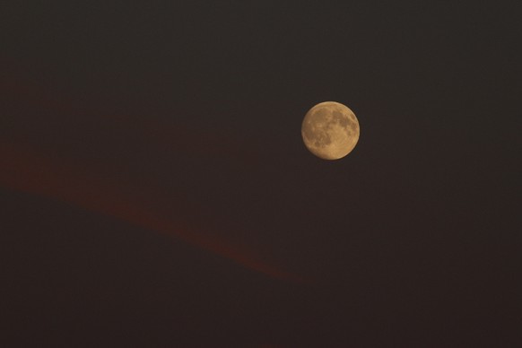 Der Mond strahlt schon in voller Pracht, obwohl die Sonne noch nicht untergegangen ist.