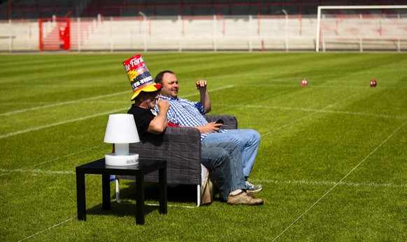 People sit on their sofas after setting them up on the pitch of the Alte Foersterei stadium for World Cup 2014 public viewing events in Berlin June 1, 2014. The Union Berlin soccer club invited its su ...