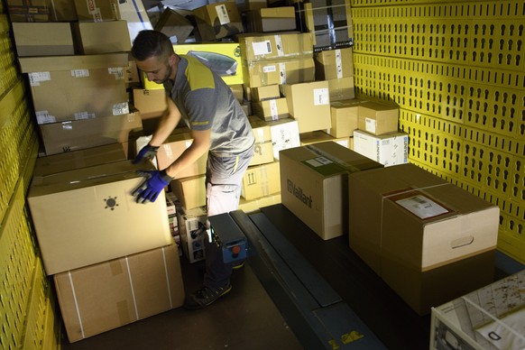 Un employe de la poste suisse decharge des paquets d&#039;un container ce mardi 20 septembre 2016 au centre colis de Daillens, Vaud. La Poste a equipe le centre colis de Daillens d&#039;une installati ...