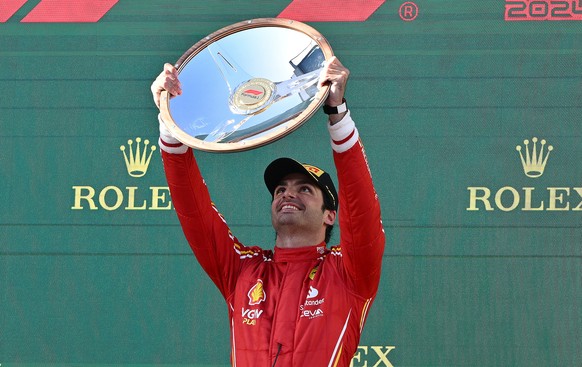 epa11240559 Carlos Sainz of Ferrari celebrates on the podium after winning the Australian Grand Prix 2024 at Albert Park Circuit on March 24, 2024 in Melbourne, Australia.  EPA/JOEL CARRETT AUSTRALIA AND N ...