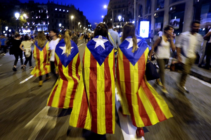 epaselect epa06243525 Catalan people wearing pro-independence &#039;Estelada&#039; regional flags leave after taking part in a protest at the Barcelona University&#039;s square against the Spanish pol ...