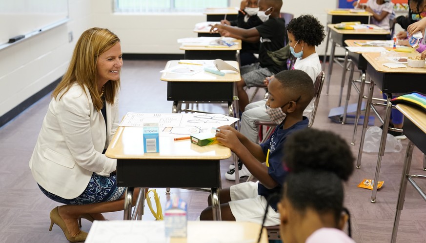 Henry County Board of Education Chair Holly Cobb, left, talks to students at Tussahaw Elementary school on Wednesday, Aug. 4, 2021, in McDonough, Ga. Schools have begun reopening in the U.S. with most ...