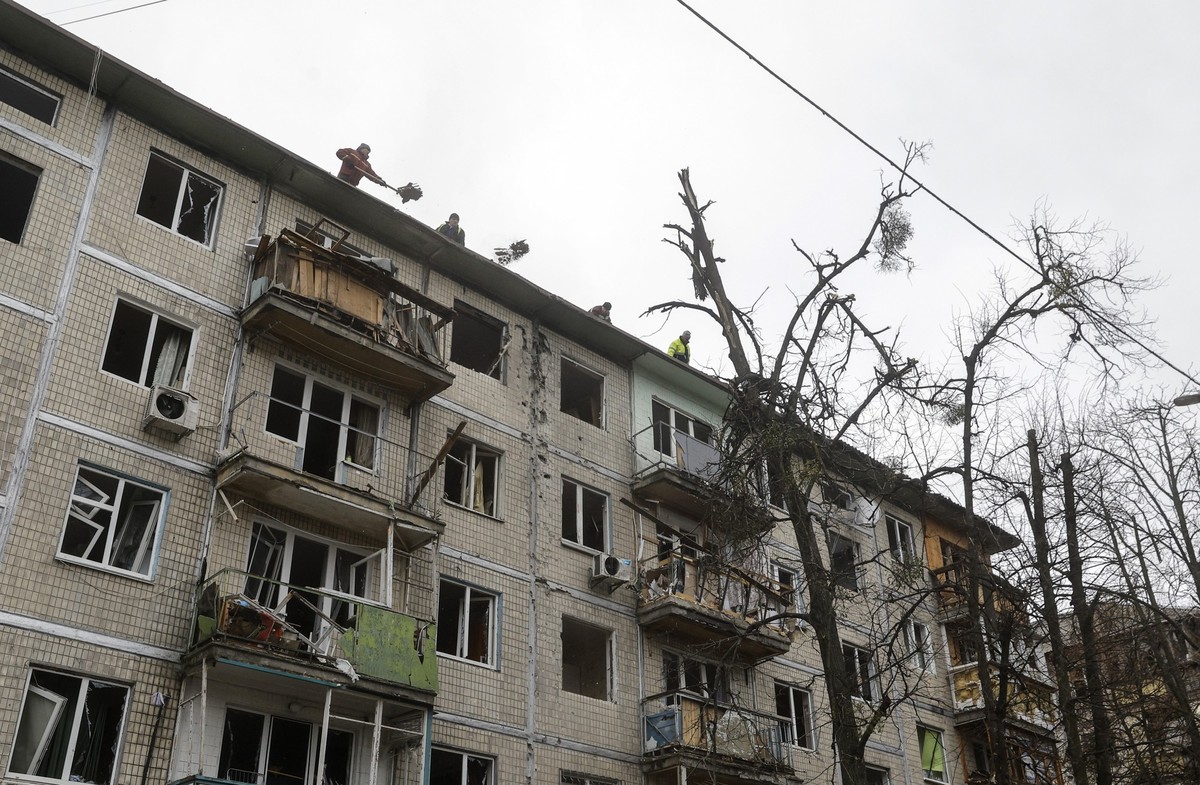 epa12609946 Ukrainian communal workers clean debris at the site of a Russian drone strike on a five-story residential building in Kyiv, Ukraine, 23 December 2025, amid the Russian invasion. At least f ...
