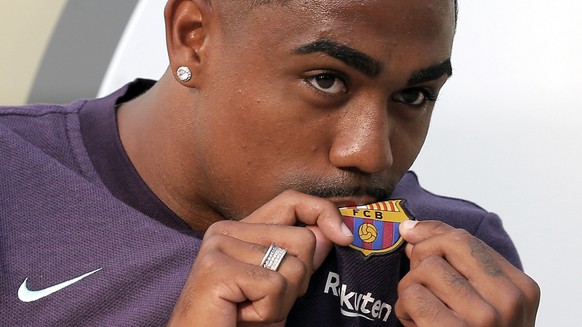 Brazilian soccer player Malcom Filipe Silva de Oliveira kisses the emblem on his shirt upon his arrival at the club&#039;s office at the Camp Nou stadium in Barcelona, Tuesday, July 24, 2018. Malcom h ...