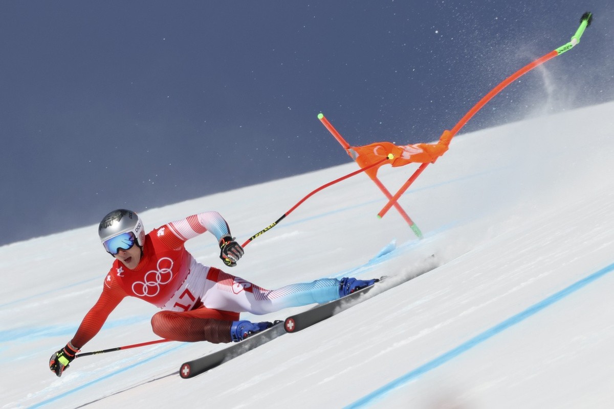 Marco Odermatt, of Switzerland sends a gate flying as he makes a turn in the men's downhill at the 2022 Winter Olympics, Monday, Feb. 7, 2022, in the Yanqing district of Beijing. (AP Photo/Alessa ...