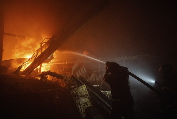 epa12752499 Ukrainian firefighters work at the site of a recent Russian airstrike on a warehouse in Sloviansk, Ukraine, 17 February 2026 (issued 18 February 2026), amid the ongoing Russian invasion. A ...