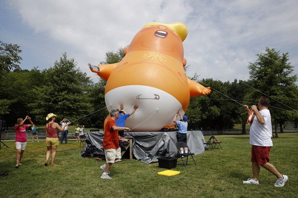 Protesters move a Baby Trump balloon into position before Independence Day celebrations, Thursday, July 4, 2019, on the National Mall in Washington. (AP Photo/Patrick Semansky)