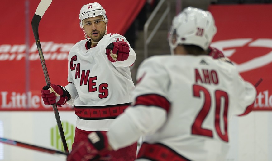 Carolina Hurricanes right wing Nino Niederreiter (21) celebrates his goal with Sebastian Aho (20) in the third period of an NHL hockey game against the Detroit Red Wings, Sunday, March 14, 2021, in De ...