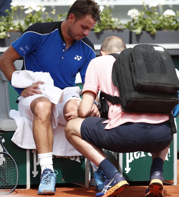 epa06768518 Stan Wawrinka of Switzerland gets medical assistance as he plays against Guillermo Garcia-Lopez of Spain during their men’s first round match during the French Open tennis tournament at Ro ...