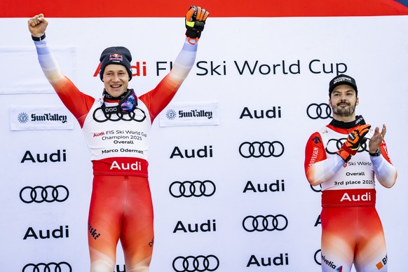 Marco Odermatt of Switzerland, left, winner of the men&#039;s World Cup overall crystal globe trophy, celebrates next to third placed Loic meillard of Switzerland, right, during the podium ceremony at ...