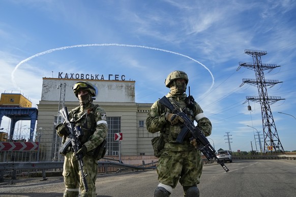Russian troops guard an entrance of the Kakhovka Hydroelectric Station, a run-of-the-river power plant on the Dnieper River in Kherson region, southern Ukraine, Friday, May 20, 2022, during a trip org ...