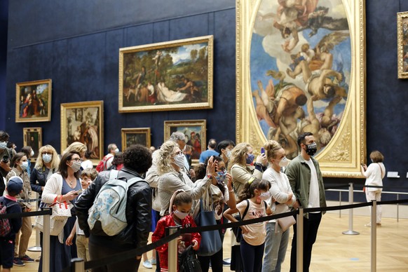 Visitors watch the Leonardo da Vinci&#039;s painting Mona Lisa, in Paris, Monday, July 6, 2020. The home of the world&#039;s most famous portrait, the Louvre Museum in Paris, reopened Monday after a f ...
