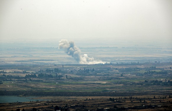 epa06894537 Smoke rises after a Russian air strike on the Syrian side of the Golan Heights in Quneitra province, as seen from the Israeli side of the border, 17 July 2018. According to reports, Syrian ...