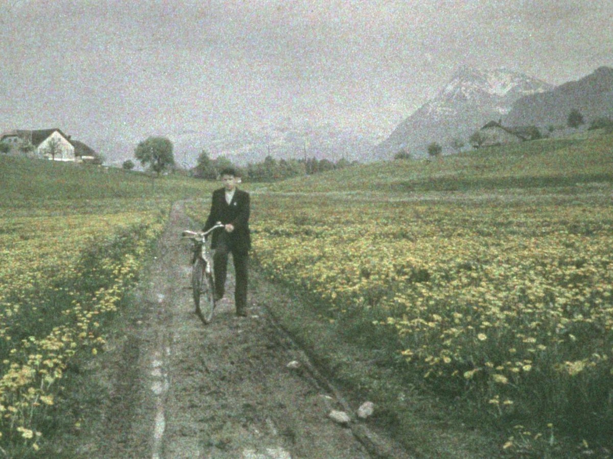 Mann mit Fahrrad, unterwegs durch eine Blumenwiese im Berner Oberland. Im Hintergrund der Niesen, um 1933.
https://permalink.nationalmuseum.ch/100327104
