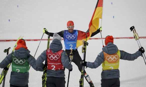 Johannes Rydzek, of Germany, center, celebrates with his teammates after winning the gold medal in the men&#039;s nordic combined team cross-country skiing event at the 2018 Winter Olympics in Pyeongc ...