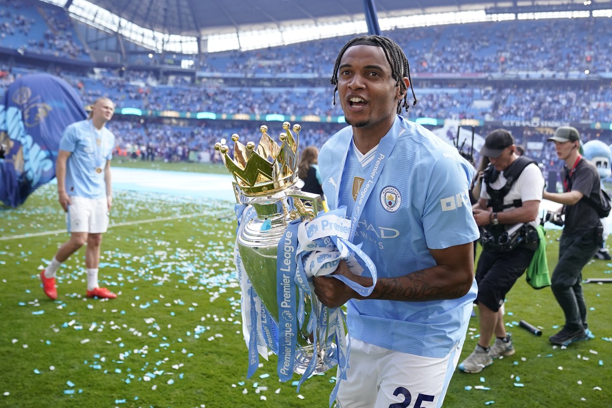 Manchester City's Manuel Akanji celebrates with the Premier League trophy after the English Premier League soccer match between Manchester City and West Ham United at the Etihad Stadium in Manche ...