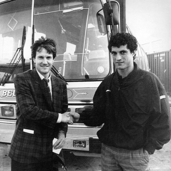 Trainer Daniel Jeandupeux, links, begruesst den Nati-Neuling Kubilay Tuerkyilmaz vor dem Mannschaftsbus in La Valletta, Malta, am 12. November 1987. (KEYSTONE/Karl Mathis)