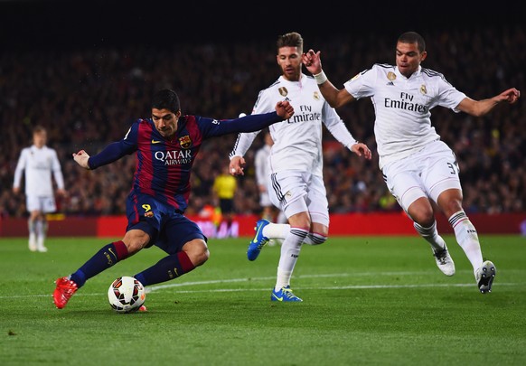 BARCELONA, SPAIN - MARCH 22: Luis Suarez of Barcelona shoots past Sergio Ramos and Pepe of Real Madrid CF to score their second goal during the La Liga match between FC Barcelona and Real Madrid CF at ...