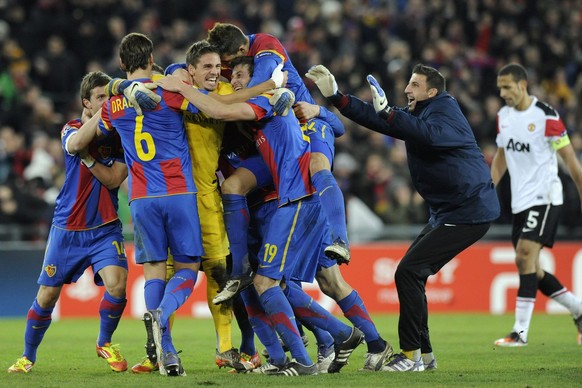 Basel&#039;s soccer players, left, celebrate in front of Manchester&#039;s Rio Ferdinand, right, after the UEFA Champions League Group C soccer match between Switzerland&#039;s FC Basel and England&#0 ...