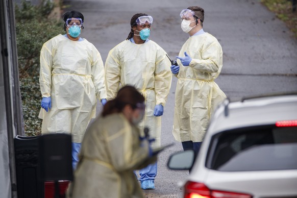 epa08307101 Healthcare workers at a drive-through COVID-19 coronavirus sample collection site in Arlington, Virginia, USA, 19 March 2020. The location, run by the Virginia Hospital Center and Arlingto ...